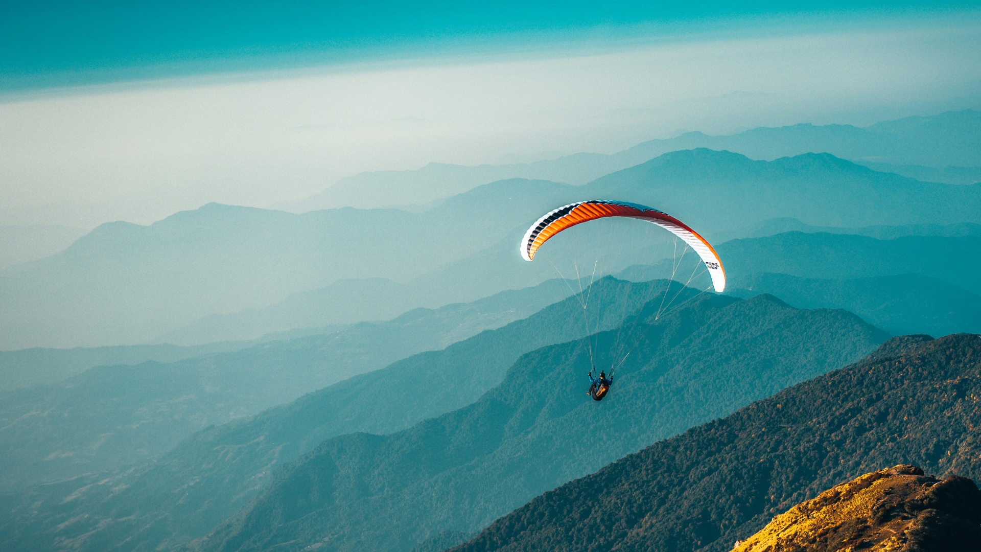 Ein Gleitschirmflieger über einer Berglandschaft